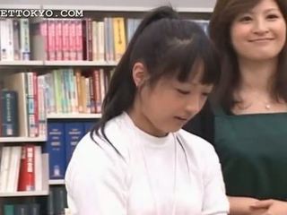 Barna ázsiai lány seducing neki koedukált -ban a könyvtár