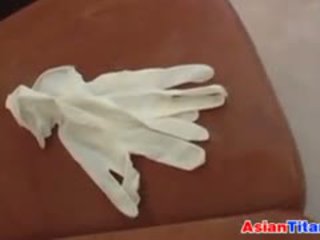 An aziatike gives një stimulim me dorë me lateks doreza